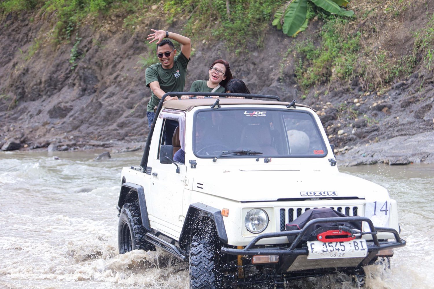 Jeep putih melintasi aliran sungai